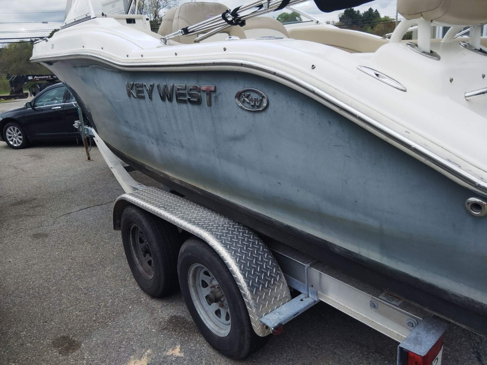 Key West center console boat before restoration — chalky, oxidized hull with heavy staining